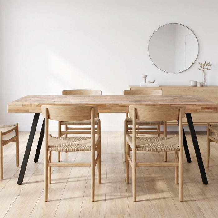 Teakhouten eettafel met zes stoelen en ruime loopruimte in een lichte eetkamer