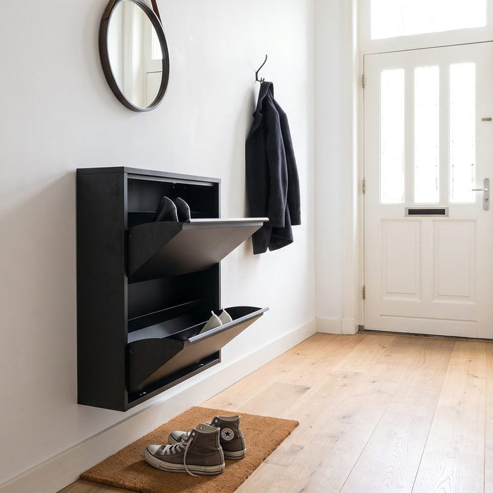 Zwarte stalen schoenenkast met kantelvakken aan de wand in een smalle hal