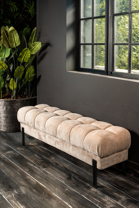 Beige gestoffeerd Melbourne bankje met gecapitonneerd zitvlak en slank zwart metalen onderstel.