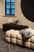 Beige en donkerbruine teddy bankjes met een vierkant gestoffeerd design en decoratieve kussens in een modern interieur.