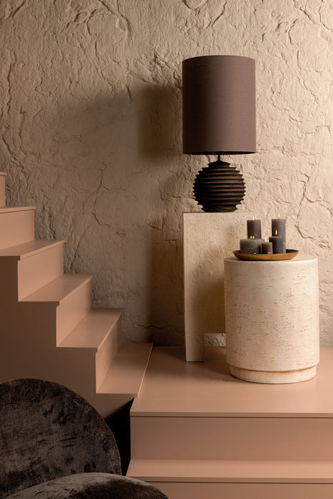 Crème kleurige Chandar bijzettafel van beton met een ronde vorm, geplaatst in een sfeervol interieur.