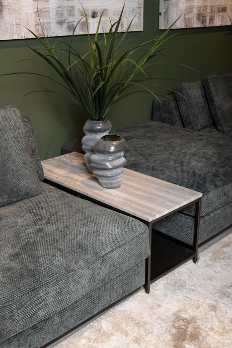 PTMD Laco bijzettafel van 40x100 cm met taupe marmeren blad en zwart metalen onderstel naast een grijze bank.