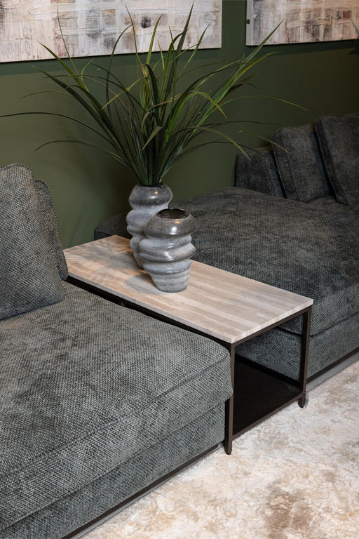 PTMD Laco bijzettafel van 40x100 cm met taupe marmeren blad en zwart metalen onderstel naast een grijze bank.