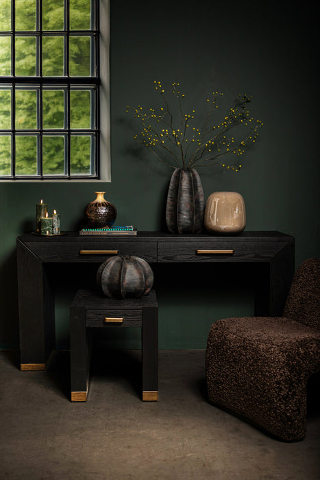 Zwarte PTMD bijzettafel van houtfineer met 45 cm blad en stijlvolle goudkleurige accenten in een sfeervol interieur.