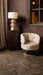 Beige polyester fauteuil Carice van PTMD met een slank metalen onderstel in een sfeervol interieur.