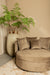 Ronde beige fauteuil van PTMD in zachte polyester fluweelstof met bijpassende sierkussens in een modern interieur.