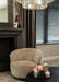 Beige polyester fauteuil Filou van PTMD met een slank metalen onderstel in een sfeervol interieur.