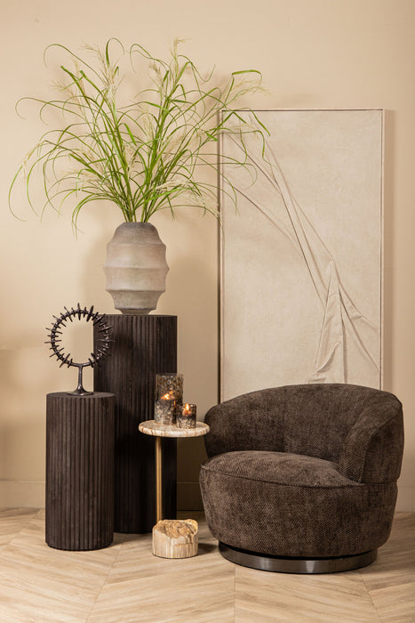 Bruine Filou fauteuil van PTMD met gestoffeerde polyester zitting en slank metalen onderstel in een warm interieur.