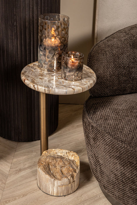 Bruine polyester fauteuil van PTMD met een slank metalen onderstel naast een marmeren bijzettafel met kaarsen.