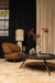 Amberkleurige fauteuil Franklyn van PTMD met polyester bekleding en slank metalen onderstel in een sfeervol interieur.