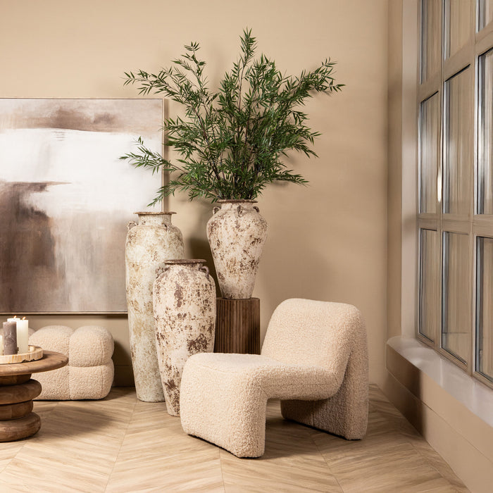 Moderne beige fauteuil van PTMD in polyester met een zachte, gestructureerde bekleding in een sfeervol interieur.