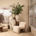 Moderne beige fauteuil van PTMD in polyester met een zachte, gestructureerde bekleding in een sfeervol interieur.