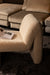 Moderne beige fauteuil van PTMD met zachte polyester bouclé bekleding en een minimalistisch, organisch design.