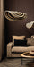 PTMD Loulou hanglamp van rotan met golvend design in beige en zwart boven een bruine bank.