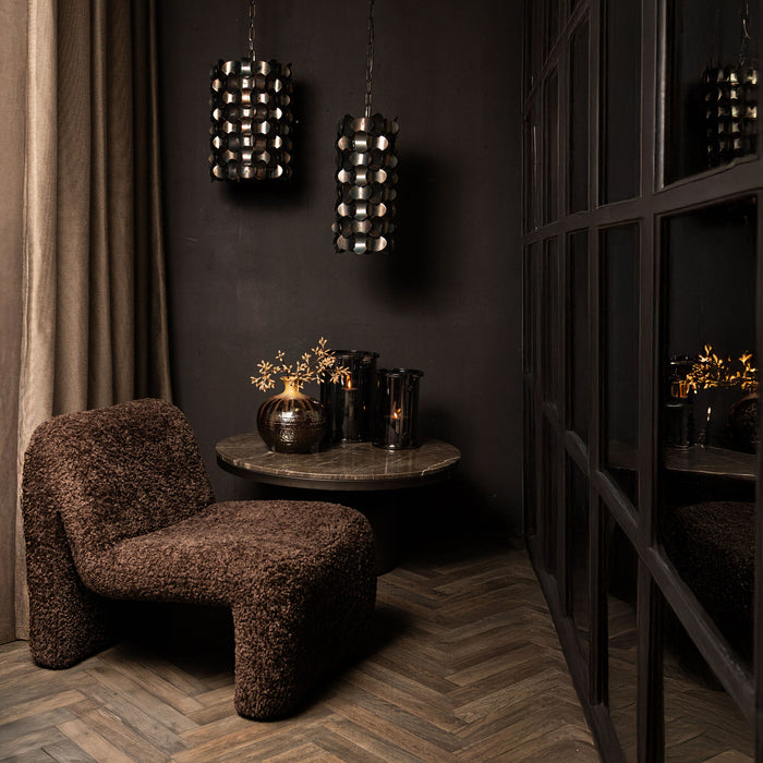 Twee zwarte, ijzeren PTMD Tijdloze hanglampen met cirkelvormig design in een sfeervol interieur.