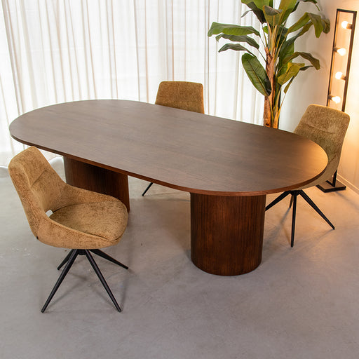 LABEL51 Oliva eettafel van 240 cm met ovaal walnoothouten blad en robuuste houten zuilpoten in een modern interieur.