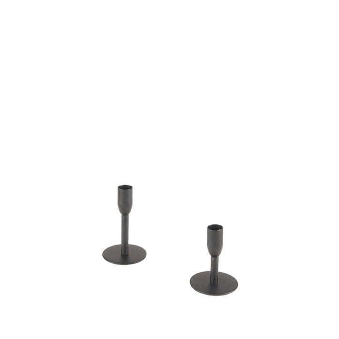 Twee minimalistische zwarte metalen kandelaars van 13 cm hoog op een ronde voet tegen een witte achtergrond.