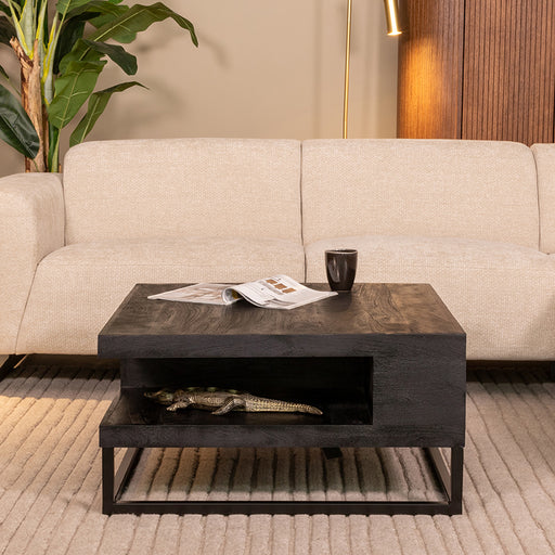 Vierkante LABEL51 salontafel Cube van zwart mangohout, 80x80 cm, met een open opbergvak in een modern interieur.