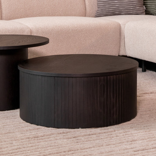 Ronde zwarte salontafel Oliva van 70 cm met een stijlvol geribbeld houten design in een modern interieur.