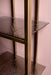 Goudkleurige metalen opbergkast Ilya van PTMD met planken van getextureerd rookglas.