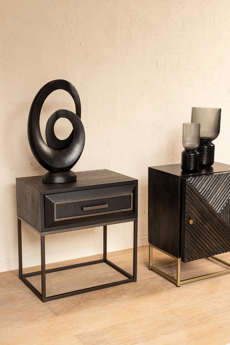 Zwarte ijzeren opbergkast Lixly van PTMD met een strak design en slank onderstel tegen een lichte wand.