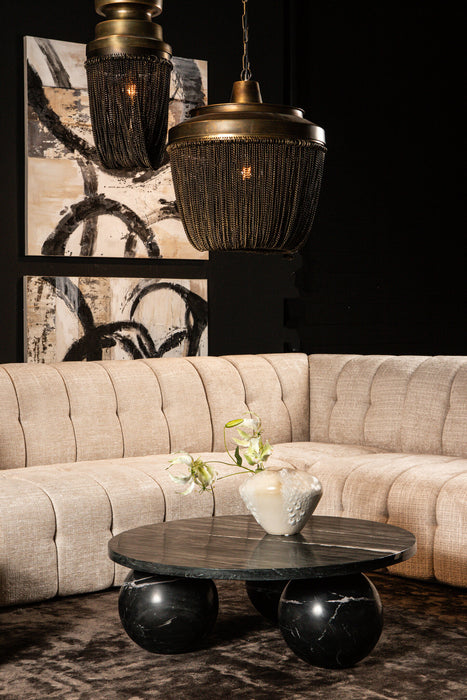 Ronde zwarte salontafel Diro van marmer en natuursteen met een uniek bolvormig onderstel in een modern interieur.